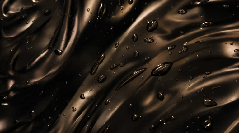 Dark abstract lubricant texture with glossy droplets for a lube compatibility guide